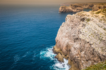 Fototapeta na wymiar High cliffs and blue ocean at Cabo Sao Vicente on coast of Portu