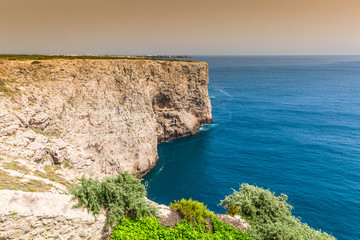 Fototapeta premium High cliffs and blue ocean at Cabo Sao Vicente on coast of Portu