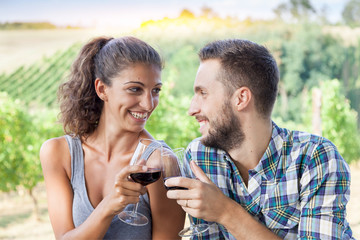 young couple of farmer toasting in a vineyard