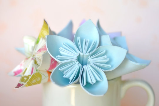 Origami flower in white ceramic cup