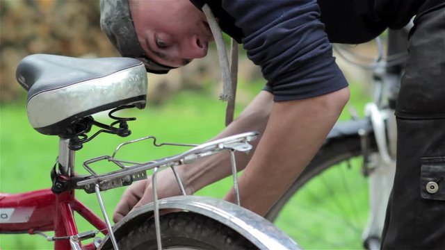 bicycle brake repair man/bowed his head man repairs a bicycle
