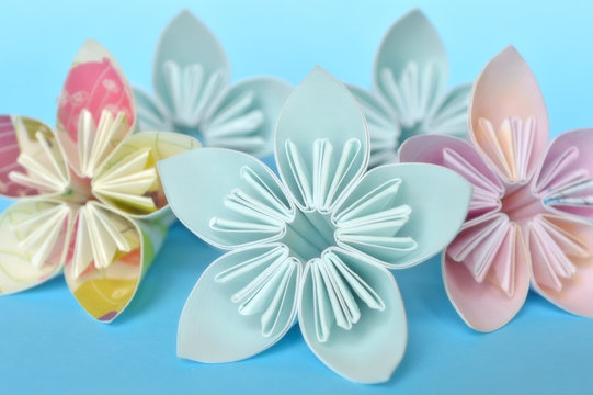 Origami flower on blue background