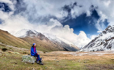 Fototapeta premium The girl has a rest after a difficult ascension in mountains