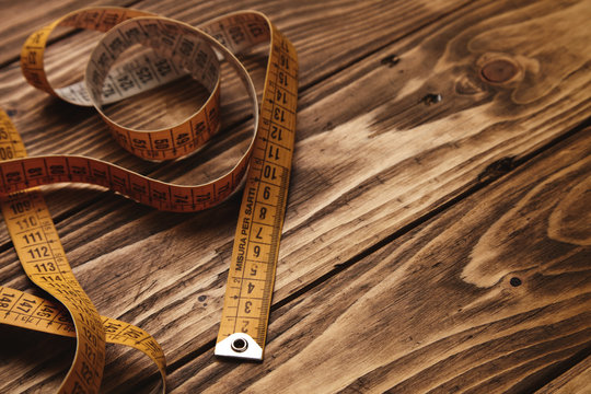 Vintage Tailor Ruler Isolated On Rustic Wooden Table Close Up