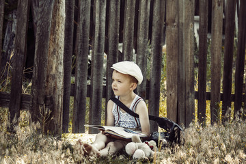 boy reads a book in a village on the nature