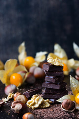 Chocolate, nuts, golden berries physalis on black background
