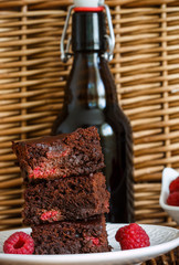 Chocolate brownie with raspberries and dark beer. Selective focus
