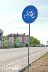 Blue bicycle way sign and lane near road