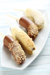 Banana covered in chocolate on a blue wooden table