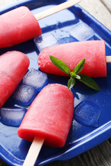 Watermelon popsicle on tray on grey wooden table