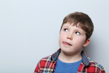 Portrait of young boy on grey background