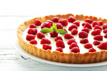 Sweet tart cake with raspberries on white wooden background