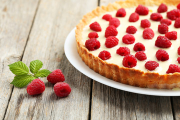 Sweet tart cake with raspberries on grey wooden background