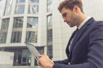 Attractive young businessman with gadget