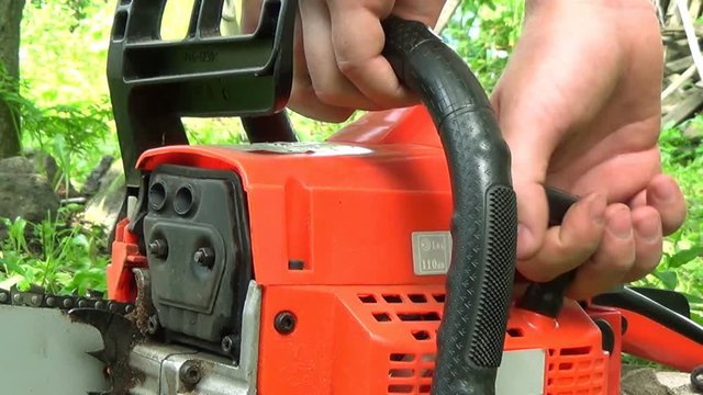 Man starts chainsaw on the outdoor