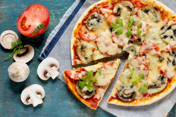 Tasty Italian pizza with tomatoes, cheese and mushrooms on a vin