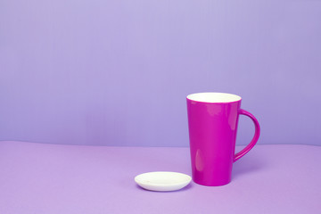 Breakfast, mug and empty dish isolated on purple background.