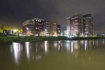 View over water to residential appartments "de Elementen" at night near the heemkanaal at the suburban Oosterheem, Zoetermeer, the Netherlands