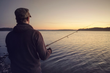 Angler am See nach Sonnenuntergang