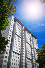 multistorey residential building surrounded by green trees