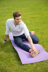 Fototapeta na wymiar Handsome sportsman doing exercise in park