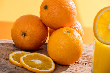 Fresh orange juice and oranges on wooden table
