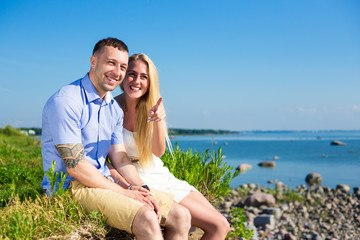 summer vacation and travel concept - happy smiling couple on roc