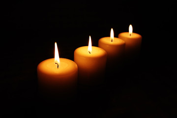 four burning candles in the dark, with space for your text