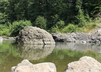 big rock in the river reflecting on the water surface