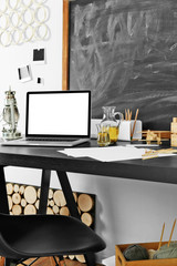 Desktop with notebook and other items on blackboard background