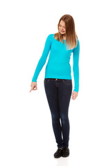 Fototapeta premium Young woman pointing down