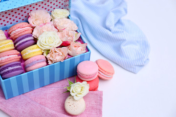 Tasty macaroons in box on white background