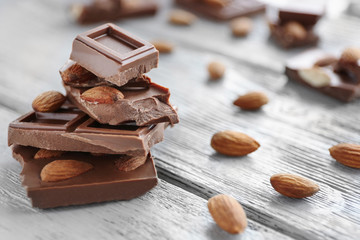 Chocolate pieces with nuts on wooden background