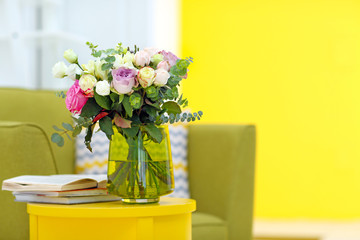 Vase with fresh roses in the room