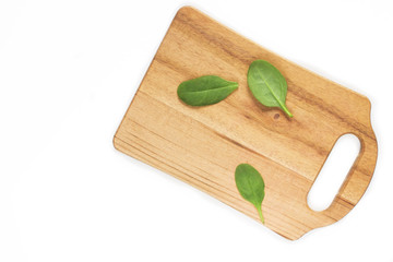 Spinach leaves on a wooden board