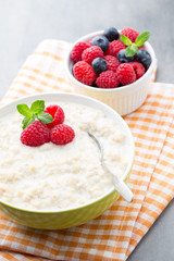 Oatmeal porridge in bowl with berries raspberries and blackberri