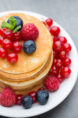 Stack of pancakes with blueberry and fresh berry.