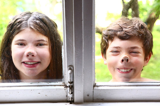 Girl And Boy With Nose Pressed Against Window