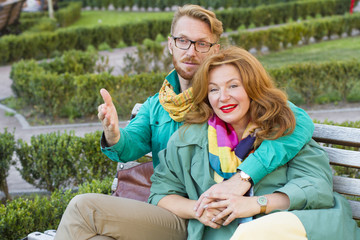 happy couple man and woman sitting in park