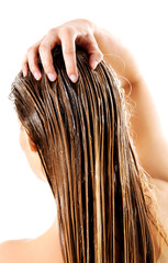 Woman applying hair conditioner. Isolated on white.