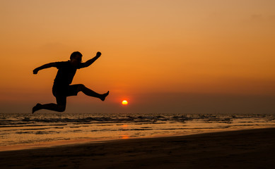 Fototapeta na wymiar silhouette of a happy man jumping on a sunset