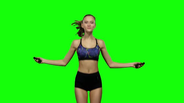Woman is jumping with a skipping rope. Green screen