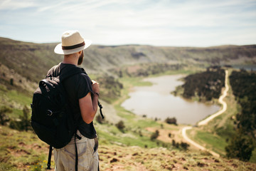 Fototapeta na wymiar Adventurer man doing hiking in a mountain with lakes