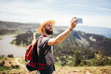 Fototapeta premium Man taking a selfie in nature and smiling