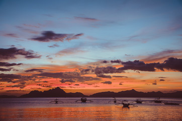 Red Sunset in El Nido, bancas in sea, Philippines