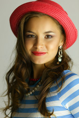 Portrait of young beautiful brunette woman in hat