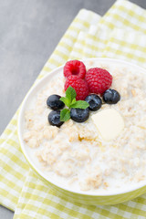 Oatmeal porridge in bowl with berries raspberries and blackberri