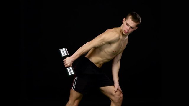 Man works on his figure. Weights for fitness. Black