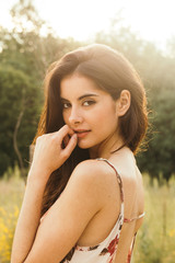 Portrait of a brunette young and pretty girl in nature with natural light