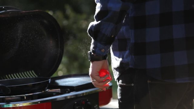 Man In Flannel Camping Outside And Making Breakfast With Eggs And Bacon